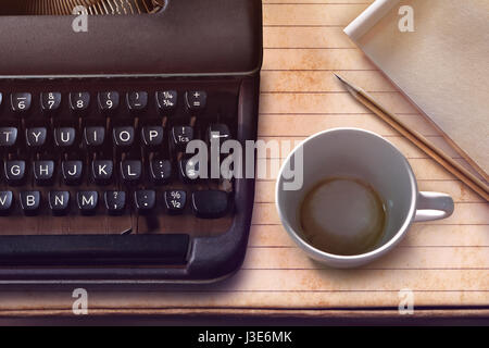 Macchina da scrivere vintage, carta, matita e vuoto tazza di caffè dall'alto. Foto Stock