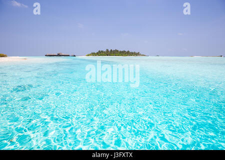 Paradiso tropicale con Crystal Clear blu oceano turchese laguna di acqua che portano a Over Water Bungalows con spiaggia di sabbia bianca Foto Stock