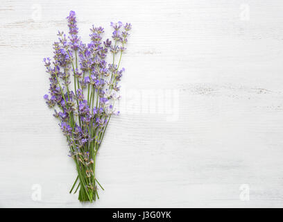 Bundle di lavanda su una vecchia tavola di legno dipinto di bianco. Foto Stock