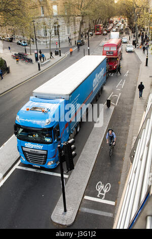 Londra, Inghilterra - Aprile 20, 2016: Un ciclista è protetto da un automezzo pesante dalla nuova costruzione est-ovest il superhighway di ciclo su Northumberland Foto Stock