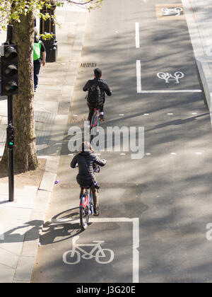 Londra, Inghilterra - Aprile 30, 2016: I ciclisti utilizzando la nuova est-ovest il superhighway di ciclo su Enbankment nel centro di Londra in una giornata di sole. Foto Stock