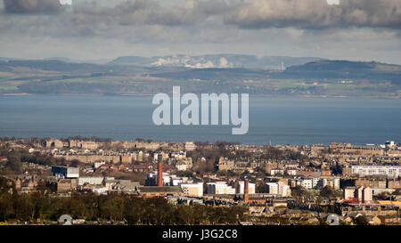 La periferia di Edimburgo conducono giù al Firth of Forth, con le colline di Fife crescente dietro, visto da Arthur sede della montagna. Foto Stock