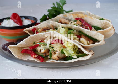 Pita riempito con petto di pollo alla brace, insalate fresche, cetriolo, paprica dolce, cipolla e salsa di yogurt su un astratto bianco sullo sfondo. Cucina casalinga. Foto Stock