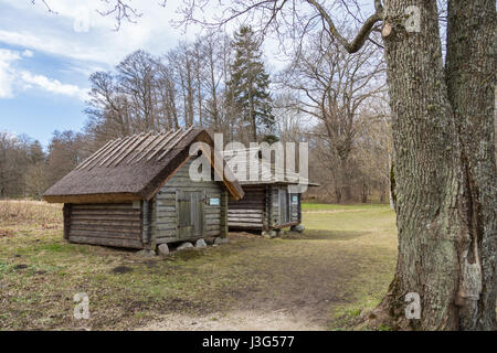 Tallinn, Estonia. La trasformazione di fabbricati agricoli in legno e pietra con tetti di paglia, installato su Estone territorio etnografico sotto il cielo aperto Foto Stock