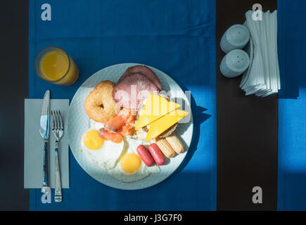 Deliziosa colazione a buffet con uova fritte, salsicce, sandwichs e succo di arancia Foto Stock