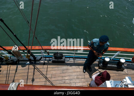 Un ufficiale della nave alta indonesiana KRI Dewaruci (Dewa Ruci) che fornisce spiegazioni ad un visitatore durante una 'casa aperta' a Giacarta, Indonesia. Foto Stock