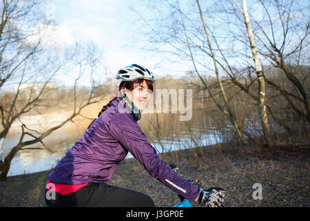 La donna corse in bicicletta park Foto Stock