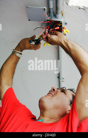 Miami Beach Florida, Ocean Drive, Presidential Condominiums, tecnico di allarme antincendio, elettricista, elettrico, fili, commercio, uomo ispanico uomini maschio, riparazione, lavoro Foto Stock