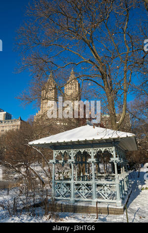 Mattino luminoso in prospettiva di un gazebo panoramico sul bordo del lago ghiacciato a Central Park dopo una tempesta invernale coperto di New York City in snow Foto Stock