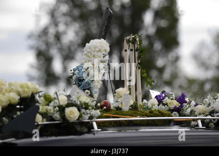 Omaggi floreali su un trasporto funebre la bara di Leslie Rhodes, morto nell'attacco di Westminster, arriva a North East Surrey crematorio in Morden davanti al suo funerale. Foto Stock