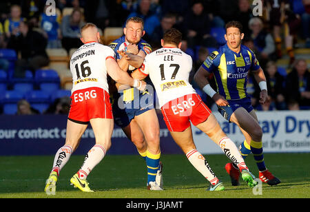 Warrington lupi' Mike Cooper è affrontato da St Helens Luca Thompson (sinistra) e Tommy Lee (a destra) durante la Betfred Super League match al Halliwell Jones Stadium, Warrington. Foto Stock