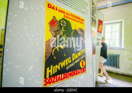 Dachau, Germania - 30 Luglio 2015: propaganda nazista poster da guerra mondiale 2 si trova all' interno di un museo del campo di concentramento. Foto Stock