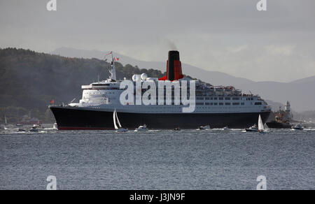 Cunard Liner QE2 vela, fino al fiume Clyde accompagnato con una flottiglia di piccole imbarcazioni nel suo ultimo viaggio passando il faro Cloch Scozia UK Foto Stock