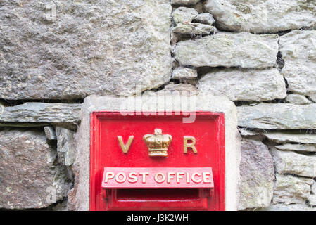 Un rosso post box incorporato in una bandiera muro di pietra nello Yorkshire Foto Stock