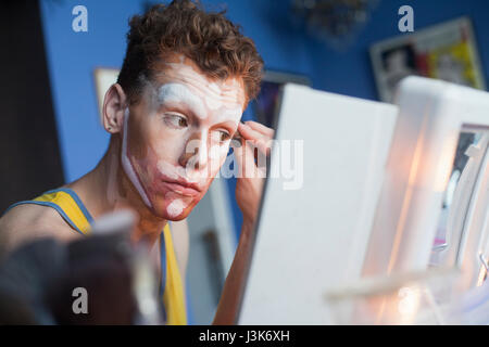 Giovane uomo applicazione trascina il trucco Foto Stock