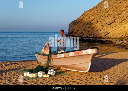 Fisherman riparazione rete da pesca in barca - Come Sifah - Muscat - Sultanato di Oman Foto Stock