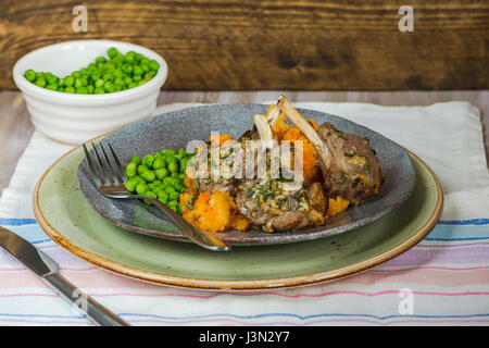 Il rosmarino costolette di agnello a cena con la carota e pastinaca mescolanza e piselli verdi Foto Stock