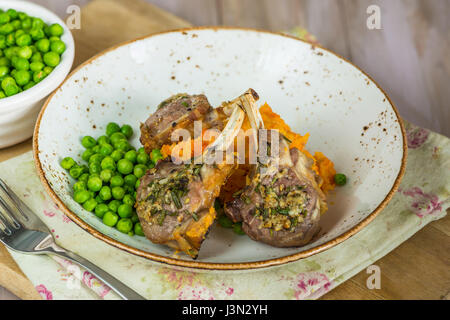 Il rosmarino costolette di agnello a cena con la carota e pastinaca mescolanza e piselli verdi Foto Stock