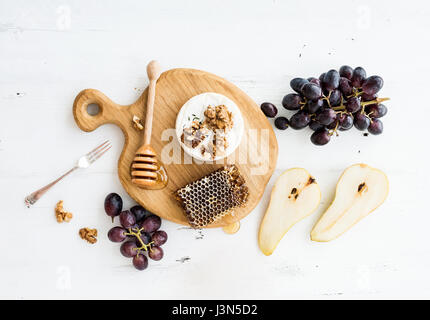 Formaggio Camembert con l'uva, le noci, pera e miele su Oak serve board Foto Stock