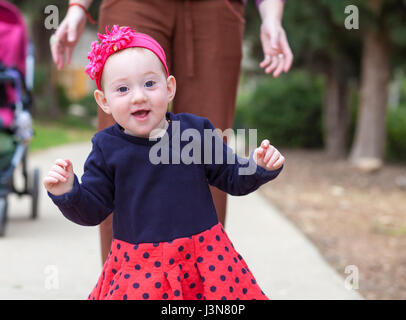 Adorabile bambina tenendo i suoi primi passi Foto Stock