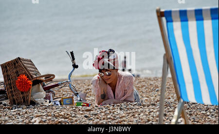 Brighton, Regno Unito. Il 6 maggio, 2017. Una giovane donna gode il caldo clima soleggiato sul lungomare di Brighton con le temperature che raggiungono alte teens celsius in alcune parti del sud est Credito: Simon Dack/Alamy Live News Foto Stock