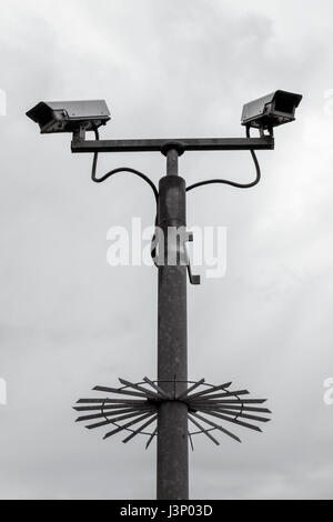 Protezione di telecamere TVCC montato su un alto palo metallico con anti-dispositivo di salita Foto Stock