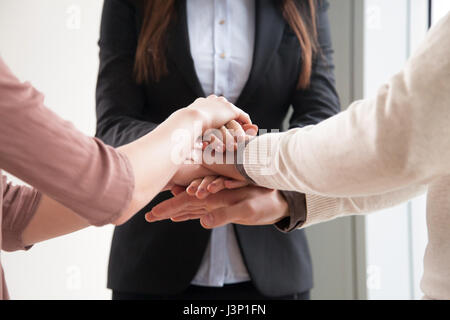 Il team Aziende di tre persone di unire le vostre mani insieme, close up Foto Stock