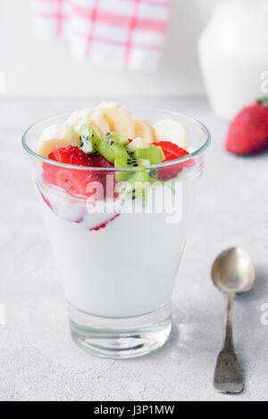 Yogurt bianco con frutta fresca e bacche di vetro, primo piano. Sana colazione o uno spuntino Foto Stock