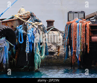 Colorate le funi di ormeggio nave tirante per un bollard in un oceano di pier in Bahamas. Foto Stock