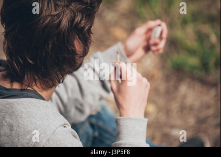 L'uomo illuminazione di un giunto di marijuana o di hashish comune di sigaretta in metropolitana Quartiere ghetto Foto Stock