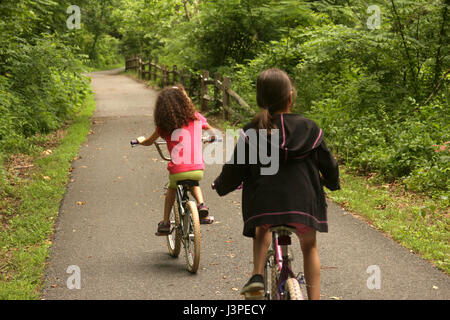 Due ragazze in sella bike nel parco nel giorno di estate Foto Stock