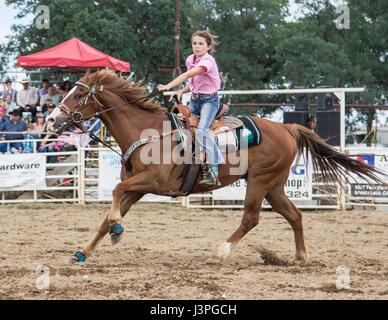 Barrel racing azione al rodeo in pioppi neri americani, California. Foto Stock