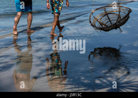 Gli uomini di camminare sulla spiaggia in Cambogia Foto Stock