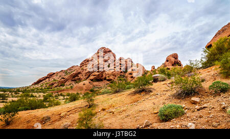 La pietra arenaria rossa buttes di Papago Park, con le sue numerose grotte e crepacci causati da erosione sotto il cielo nuvoloso, nella città di Tempe, Arizona negli Stati Uniti Foto Stock