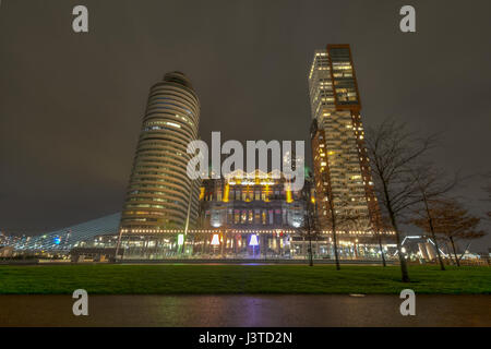 L'hotel new york, situato in Kop van Zuid quartiere di rotterdam, Paesi Bassi, preso dalla fine del molo di notte Foto Stock