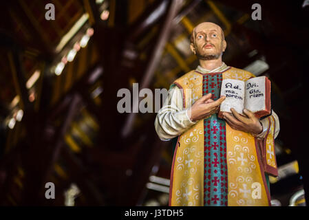 Statua di Sant'Ignazio di Loyola che mostra un libro con la frase latina scritta all'interno, alla chiesa di Sant'Ignazio Loyola a Sikka, Isola di Flores, Indonesia. Foto Stock