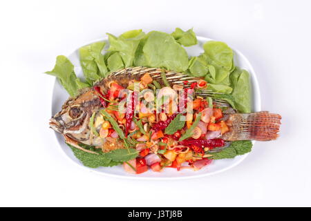 Cucina thailandese, piccante e aspro insalata di erbe fritte di Tilapia con baby foglie di tamarindo isolati su sfondo bianco. Foto Stock