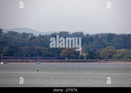 Primo grande Western treno intercity sulla Riviera linea in movimento da sinistra a destra adiacente al fiume Exe vicino a St Clements Chiesa Powderham Foto Stock