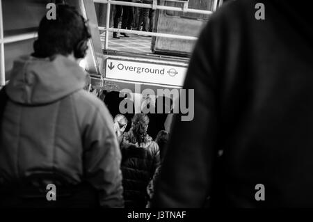 I pedoni a piedi giù per le scale a Whitechapel stazione della metropolitana nella zona est di Londra, verso la Overground piattaforme. Foto Stock