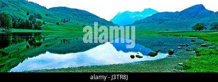 Ancora un silenzio mattina all'iconico Blea Tarn nel Lake District Cumbria con le colline e Langdale Pikes in background Foto Stock