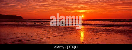 Un colorato fiery tramonto panoramico dalla spiaggia presso Borth in Galles Centrale Foto Stock