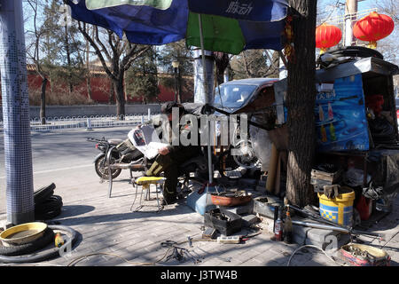 Il meccanico in officina sulla strada di Pechino, Cina, 24 febbraio 2016. Foto Stock