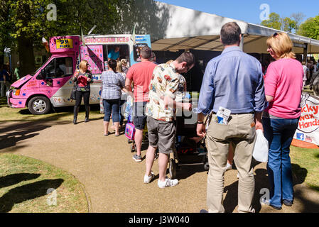 La gente in coda fino a un gelato van durante una giornata di sole. Foto Stock