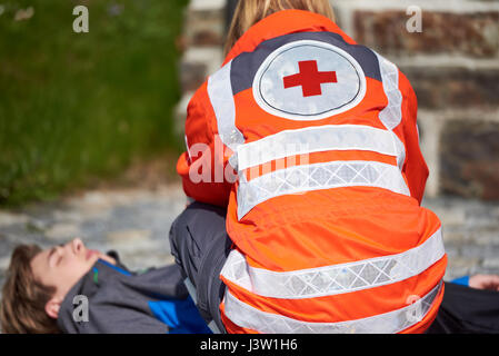 Professional paramedico dando inconscio giovane di primo soccorso Foto Stock