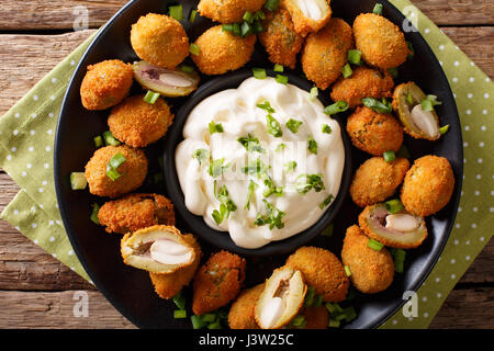Gustosi impanati olive fritto con mandorle close-up e cremosa salsa su una piastra orizzontale di vista da sopra Foto Stock
