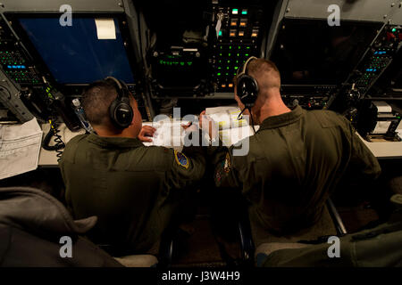 Stati Uniti Air Force Il Mag. Izzy Remo, sinistra, un conduttore di prova-airborne, E DEGLI STATI UNITI Air Force Capt. Greg Carter, a destra di un vice-missile equipaggio combat commander-airborne, sia dai conti nella 625 a operazioni strategiche Squadron, andare oltre il lancio di missili durante le procedure di volo gloria 220 sopra l'Oceano Pacifico, 26 aprile 2017. Gloria Viaggio è operativo un test di lancio che continua una lunga storia di Gamma Western lancia utilizzata per verificare e convalidare e migliorare la capacità della nazione di forza di missili a gittata intercontinentale. (Foto a cura di sicurezza) (U.S. Air Force foto di Airman 1. Classe Keifer Bowes) Foto Stock