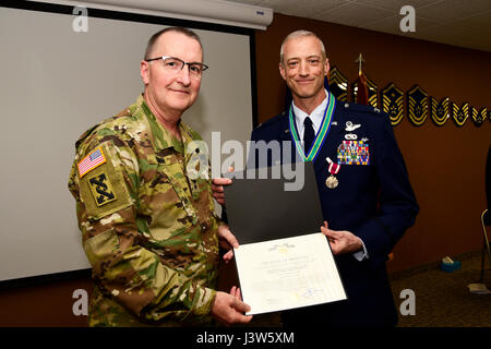 Montana Guardia Nazionale Aiutante Generale Il Mag. Gen. Matteo Quinn presenta il Montana Guardia Nazionale Distinguished Service Medal Col. Patrick Hover durante il suo pensionamento cerimonia tenutasi presso il centoventesimo Airlift Wing a Great Falls, Mont. Aprile 28, 2017. Passare il puntatore del mouse ultimo servito come il comandante del centoventesimo Operations Group. (U.S. Air National Guard foto di Senior Master Sgt. Eric Peterson) Foto Stock