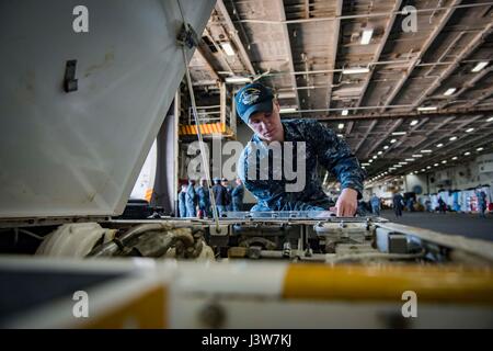 170502-N-LA456-017 Norfolk, Virginia (2 maggio 2017) Aviazione Equipaggiamento di supporto tecnico Airman apprendista Tanner Swartz dalla prospettiva, Penn., esegue le operazioni di manutenzione su un spotting dolly nella baia di hangar della portaerei USS Dwight D. Eisenhower CVN (69) (IKE). Ike è attualmente pier lato durante la fase di supporto della flotta ottimizzato il piano di risposta (OFRP). (U.S. Foto di Marina di Massa Specialista comunicazione marinaio K. A. DaCosta) Foto Stock