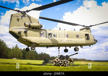 Soldati con 1° Battaglione, 319Airborne campo reggimento di artiglieria, ottantaduesima Divisione Aerotrasportata manovra di artiglieria dopo l'attacco di un M119A3 obice alla pancia di un CH-47F elicottero Chinook assegnato al terzo supporto generale del battaglione di aviazione, 82a combattere la Brigata Aerea imbracatura durante le operazioni di carico su Fort Bragg, N.C., 4 maggio. (U.S. Esercito foto di Sgt. Steven Galimore) Foto Stock