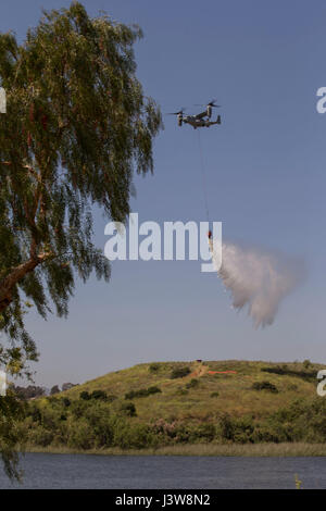 Un MV-22 Osprey gocce acqua durante il 2017 Wildland esercitazione antincendio (WLFFEX) presso il lago O'Neil su Camp Pendleton, California, 4 maggio 2017. Il WLFFEX è un annuale evento di formazione per esercitare la lotta antincendio sforzi da parte di aerei e di terra da assests Marine Corps impianti - West, Marine Corps base Camp Pendleton, terzo Marine Air Wing, Navy Regione Sud Ovest, terza flotta, CAL FUOCO e San Diego County Sheriff's Department. (U.S. Marine Corps foto di Cpl. Brandon Martinez) Foto Stock